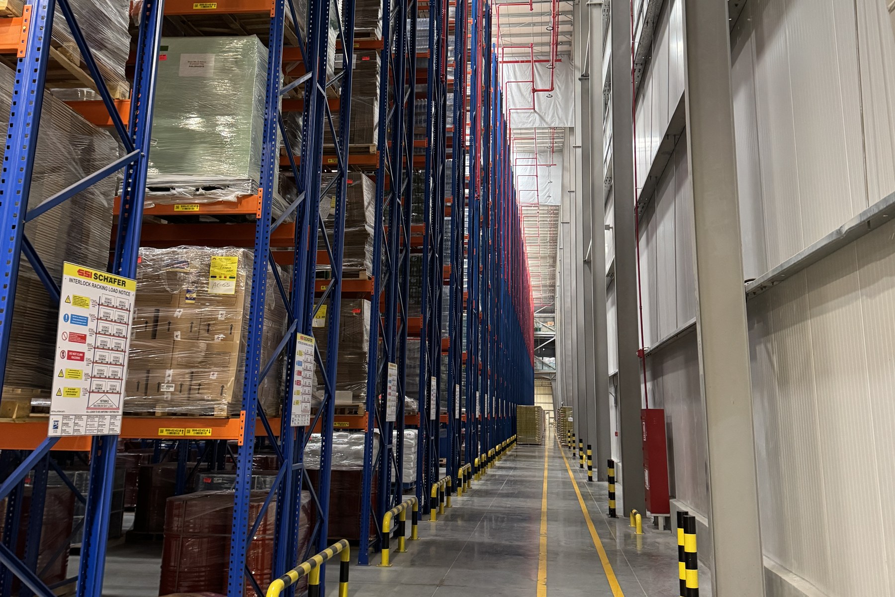 Loaded pallet racking beside an insulated wall, photographed during a facility visit; not a Nord Hub facility
